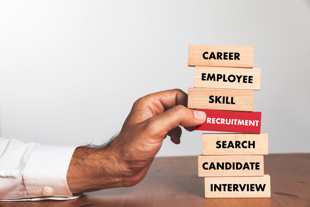 a stack of wooden blocks with words relating to recruitment to accompany a blog about how Permanent Recruitment Specialists Help You